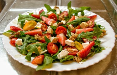 Fresh and healthy salad with fruits, vegetable, rocket and nuts