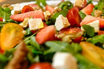 Fresh and healthy salad with fruits, vegetable, rocket and nuts