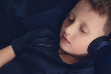 boy listening to music in headphones Lying in bed