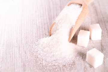 White cane sugar on a light wooden background