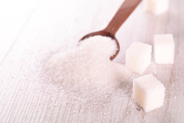 White cane sugar on a light wooden background