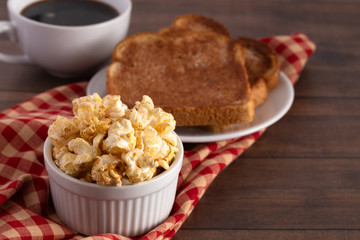 Bowl of Cinnamon Toast Flavored Popcorn on a Wooden Table