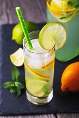 Tonic with lemon, lime and ice in a transparent glass on the table