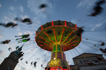 blured carousel spinning with people © Anton Blanke