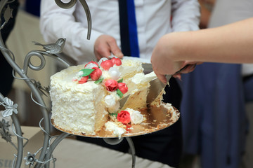 Kelnerka dzieli tort na przyjęciu weselnym. - obrazy, fototapety, plakaty