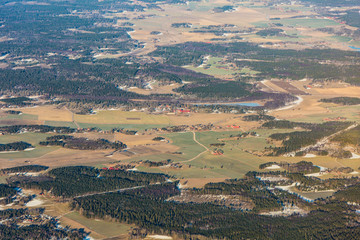 Obraz premium Sweden landscape with forest, field and small settlements north of Stockholm during winter - aerial view 
