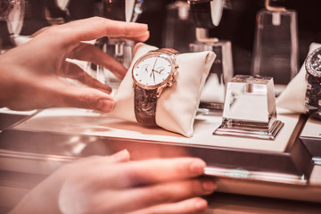 Close-up of the seller's hand shows the exclusive men's watch from the new collection in the luxury jewelry store