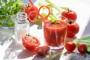 Tomato juice in glass with celery, cherry tomato, white wood background, closeup