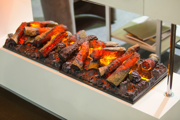Modern electric fireplace with imitation of flame and firewood. Designer electric fireplace