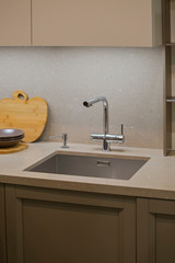 Kitchen faucet, modern gray kitchen in loft style, gray table, luxury faucet kitchen