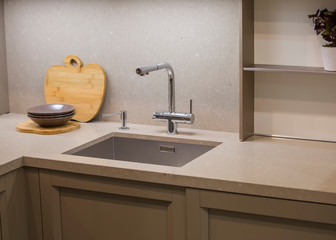 Kitchen faucet, modern gray kitchen in loft style, gray table, luxury faucet kitchen