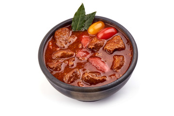 Beef stew or goulash, close-up, isolated on white background