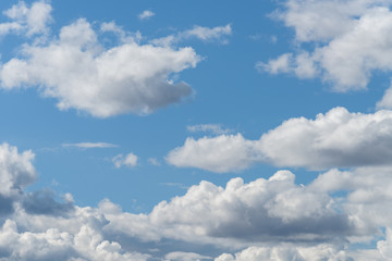 The blue sky with white clouds, in the rays of sunlight.