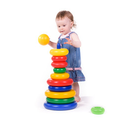 Fototapeta na wymiar Child collects toys. Small child plays with teaching colored toys. Isolated over white background