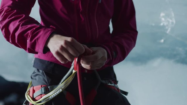 Close up of midsection of ice climber securing rope to harness / Palmer, Alaska, United States