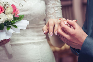 Young bride and groom exchange rings during the wedding.