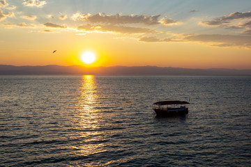 Sunrise over the sea, view of the drifting boat.
