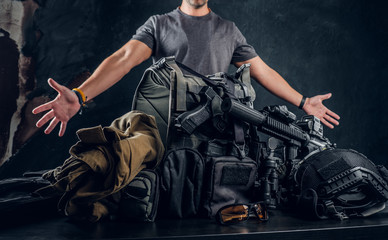 Casually dressed man showing his military uniform and equipment. Modern special forces equipment....