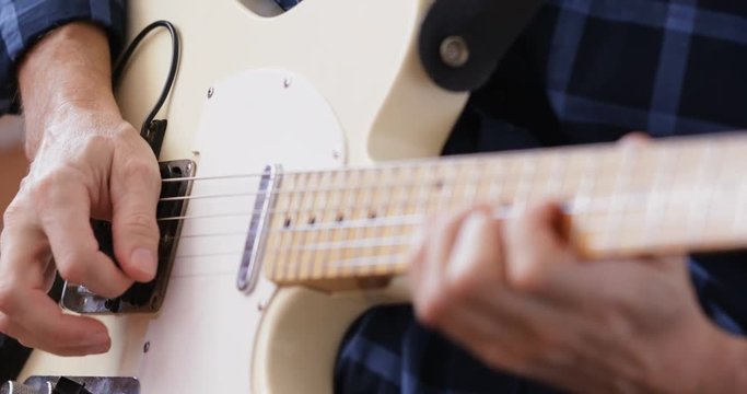 Man practicing electric guitar, close-up
