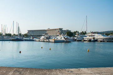 White boats on the pier are parked near the hotel