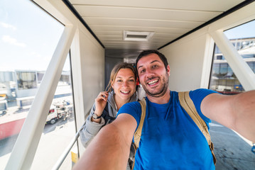beautiful caucasian couple traveller taking selfie in the airport before journey on the flight