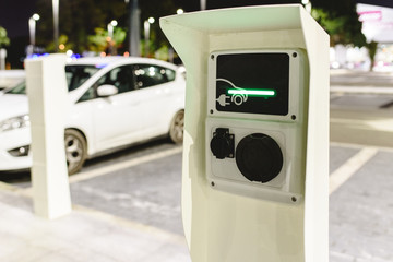 Public post charger of electric vehicles placed in the parking lot of a supermarket.