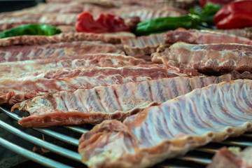 Raw pork ribs on a grill on a barbecue.