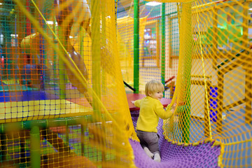 Obraz na płótnie Canvas Happy little boy having fun in amusement in play center. Child playing on indoor playground.