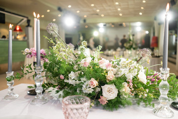 Fototapeta na wymiar Floral decoration for wedding ceremony romance dining. Wedding banquet , festive decor. Bouquet from spring and summer flowers. Table layout. Restaurant interior. Concept of service and catering.