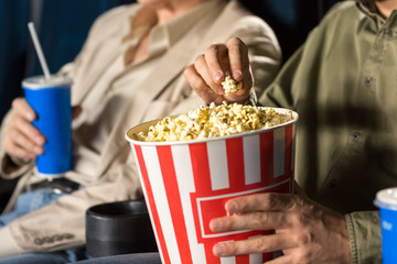 Senior man enjoying movies with his mature son together at the cinema
