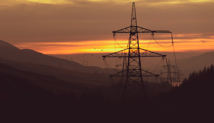 Power pylons during the sunset follow the flow of the landscape in the middle of the Peak District - Taken in Winter 2019