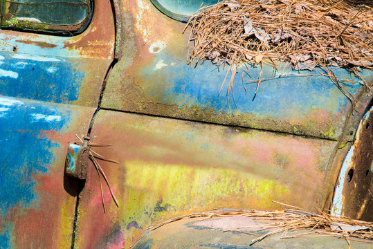 Old vintage rustic car sitting in a junk yard.
