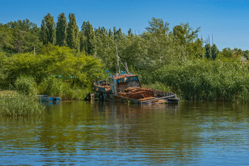 Fototapeta na wymiar Abandoned old rusty fishing boat on shore