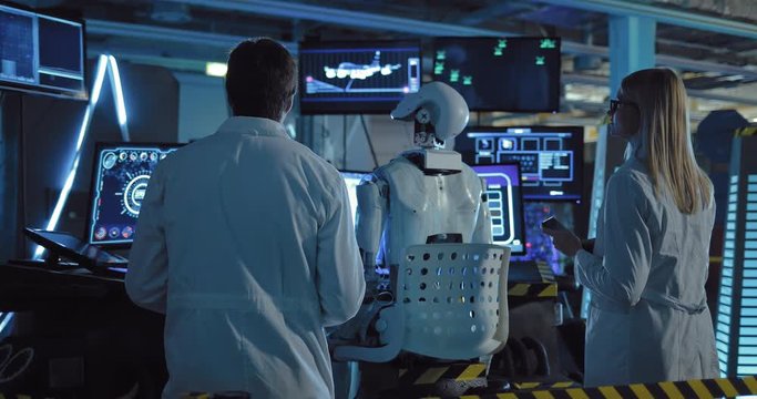 Scientists are testing humanoid in the space station's technical laboratory. Surveillance screens included.