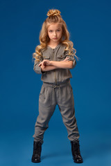 Little girl with a long curly hair in a fashionable clothes