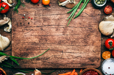 Voedsel koken achtergrond, ingrediënten voor de bereiding van veganistische gerechten, groenten, wortels, specerijen, champignons en kruiden. Oude snijplank. Gezond voedselconcept. Rustieke houten tafel achtergrond, bovenaanzicht