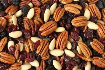 Mix of pecan nuts, black raisins jumbo, cranberries, almonds without peel. Background. Closeup.