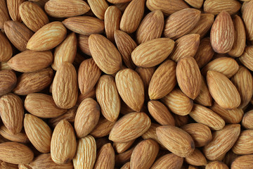 Background of big raw peeled almonds situated arbitrarily