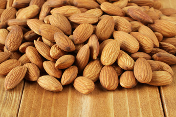 A bunch of almonds on brown toned wooden table. Closeup