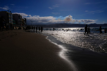Silhouettes of people enjoying a sunny day at Las Canteras in Las Palmas de Gran Canaria