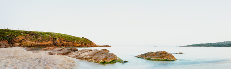 Panorama Küste in Korsika am Strand mit Blick auf Steine, Felsen mit und das Meer in grüner sommerlicher Natur