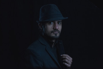 dark portrait of a young man with hat