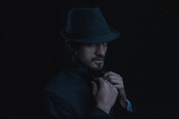 Fototapeta na wymiar dark portrait of a young man with hat