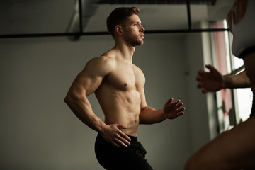 Young athletic man warming up before sports training in a gym.