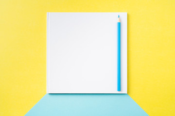 white square notebook on yellow and blue paper