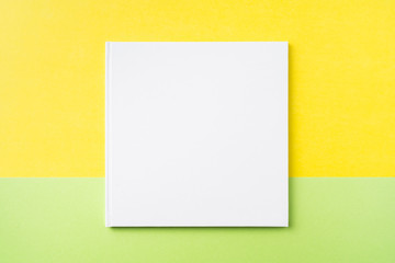 white square notebook on yellow and green paper