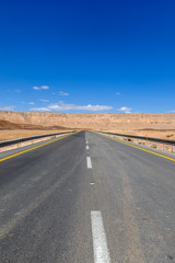 Fototapeta na wymiar Empty highway leading to the mountains through the desert