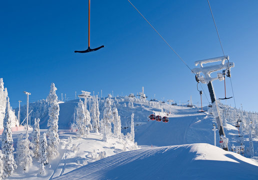 Kuusamo / Finland: T-bar lift, gondola and chairlift in the Ruka ski area on a beautiful and sunny day in February