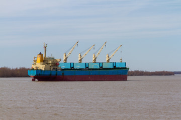 Bulk cargo ship at anchorage with open holds