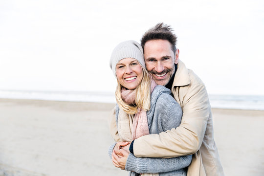 Portrait of happy couple hugging on beach